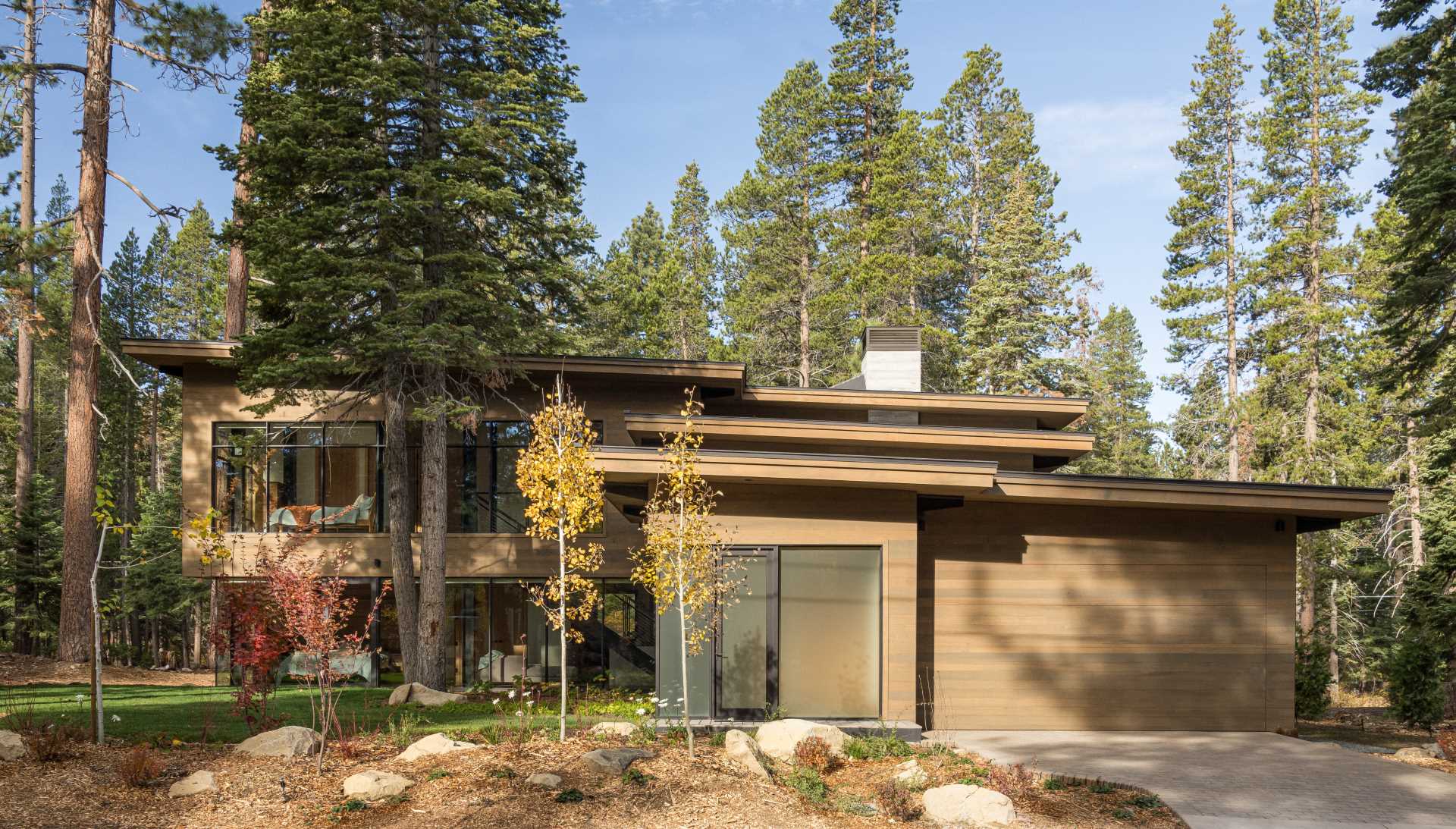 A modern home has an intentionally muted yet refined palette of natural materials including cedar, oak, fir, and steel, allowing the house to harmoniously blend with the surroundings.