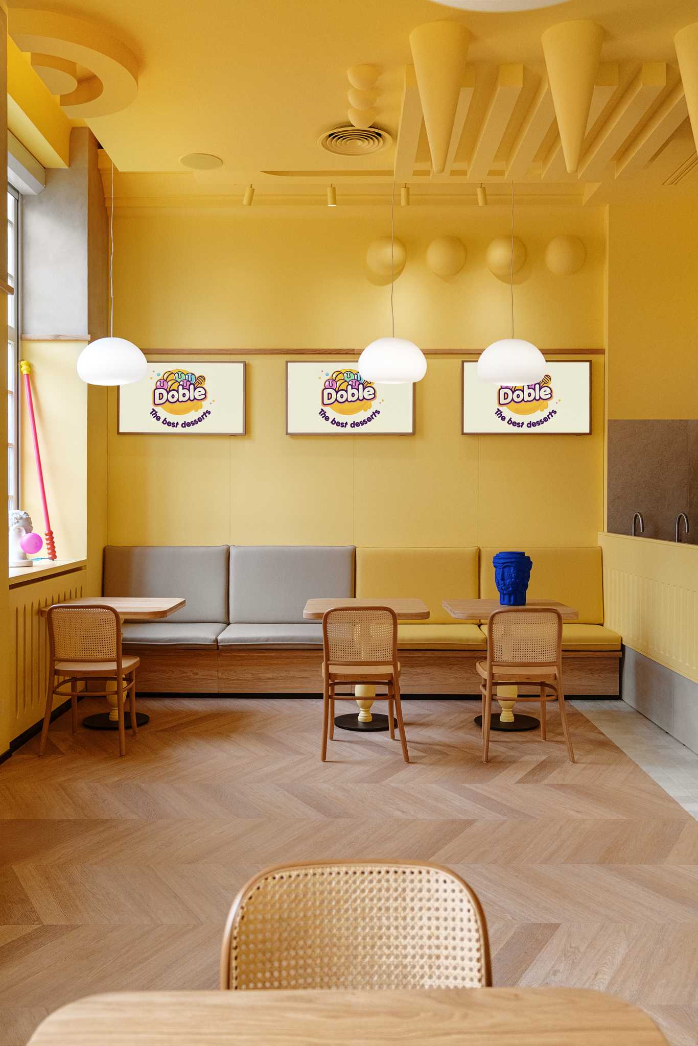 A modern dessert cafe with a bright yellow interior and sculptural ceiling.