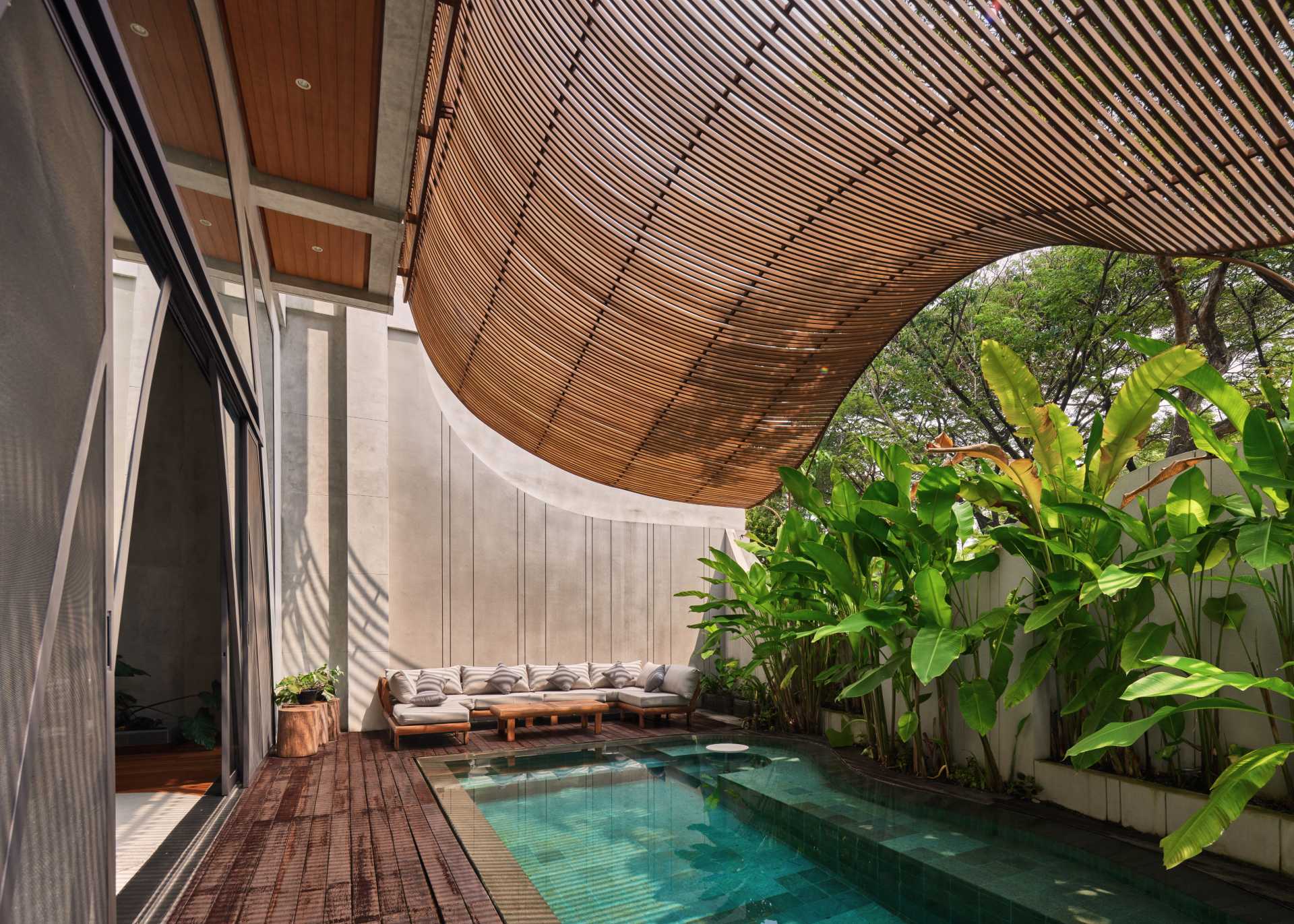 This pool, which is shaded by the screens, runs along the living room and aids in keeping the home cool.