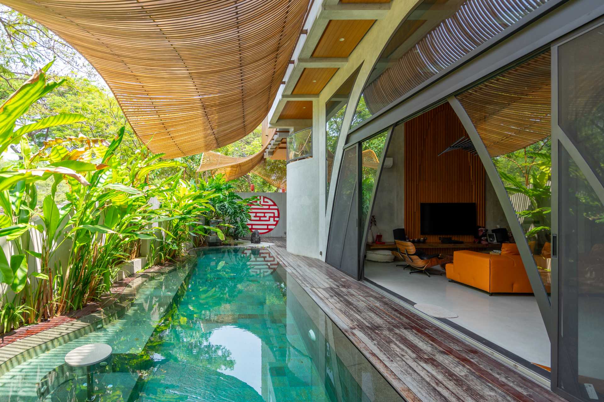 This pool, which is shaded by the screens, runs along the living room and aids in keeping the home cool.