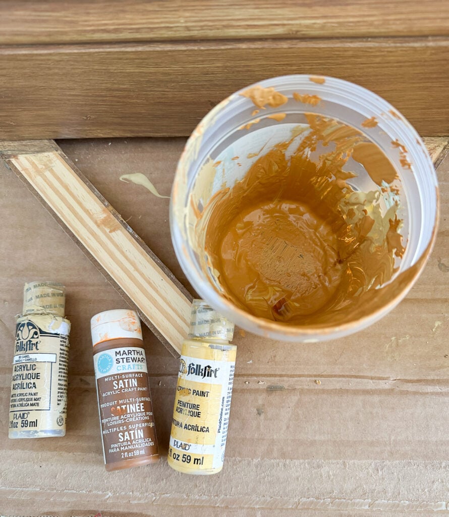 Mixing clear mixing glaze with gold and yellow paint use to create a faux wood finish.