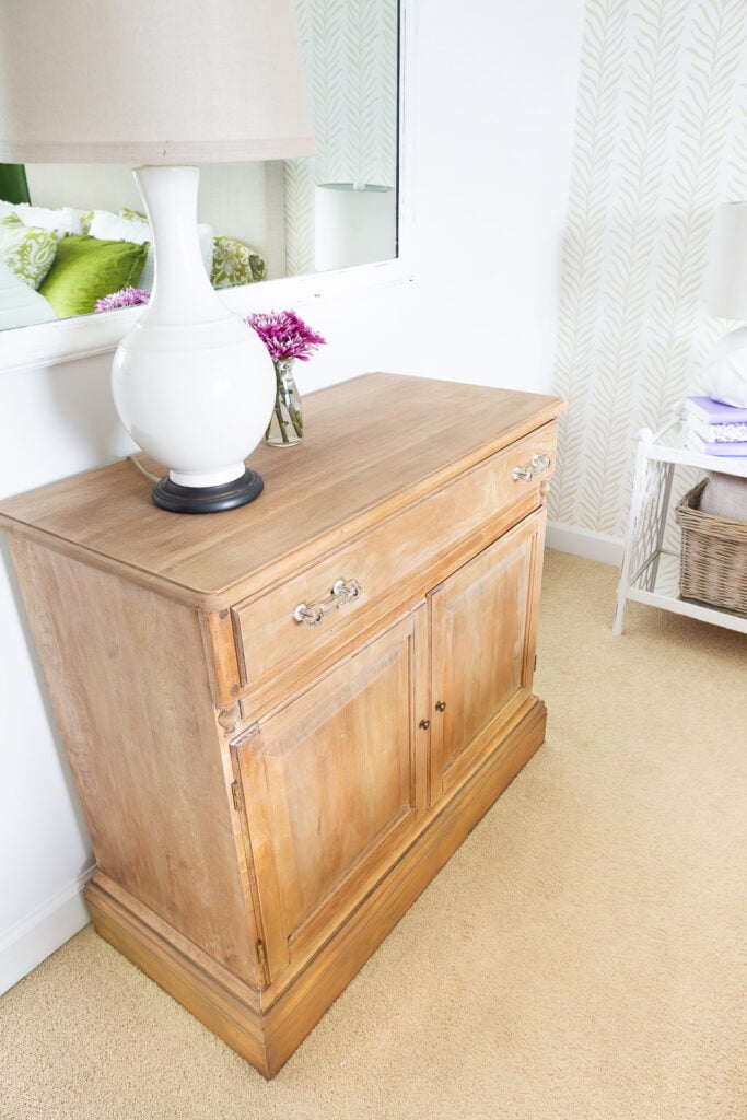 a just paint stripped cabinet against a wall in a bedroom.