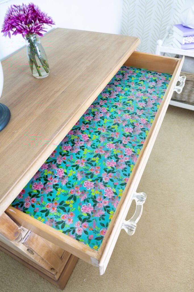 lining a drawer with colorful gift wrap.