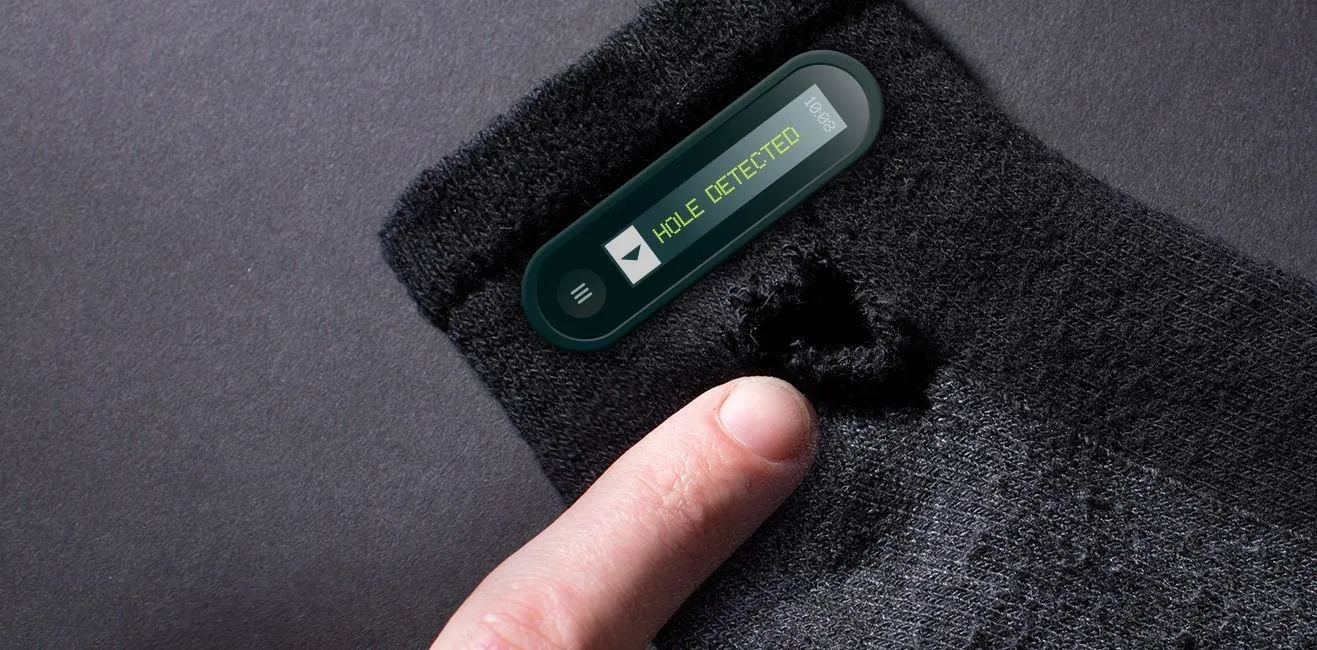 Wearable technology integrated into a black textile item with a visible tear.