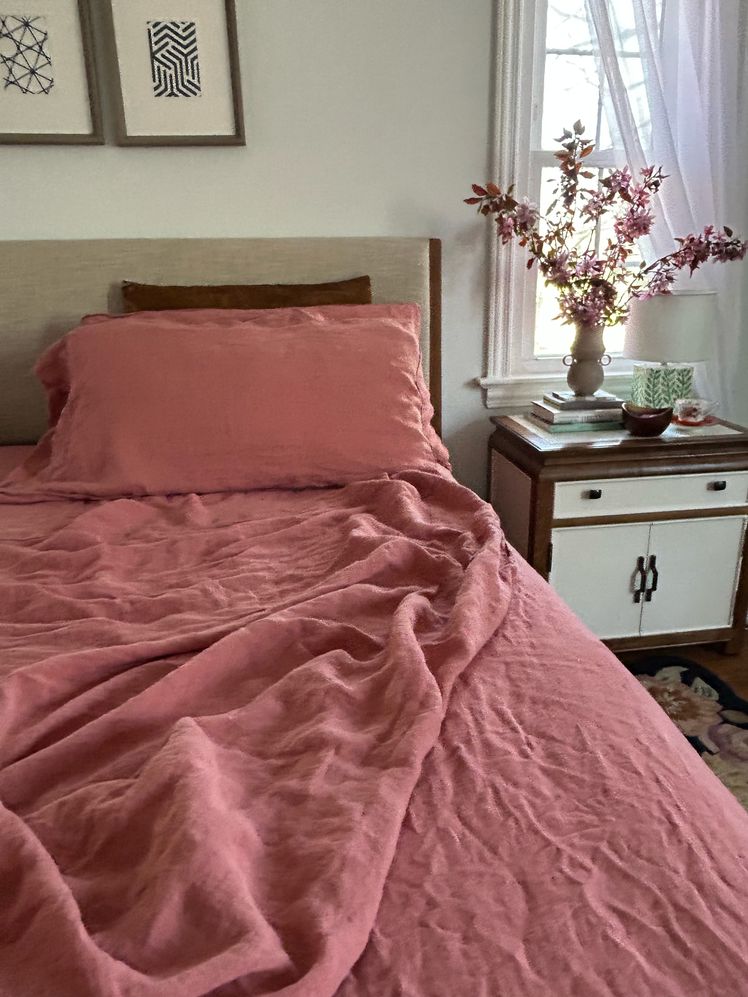 Bed made with pink sheets.