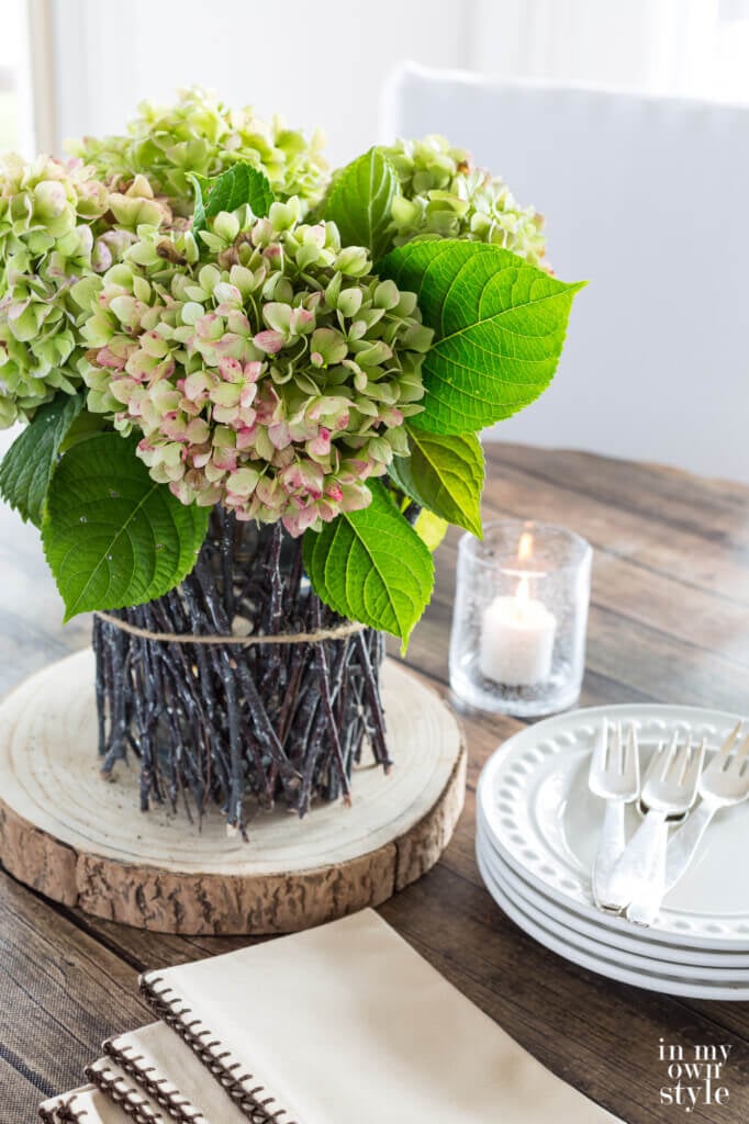 Dining table fall centerpiece. Tree twig vase with dried hydrangeas.