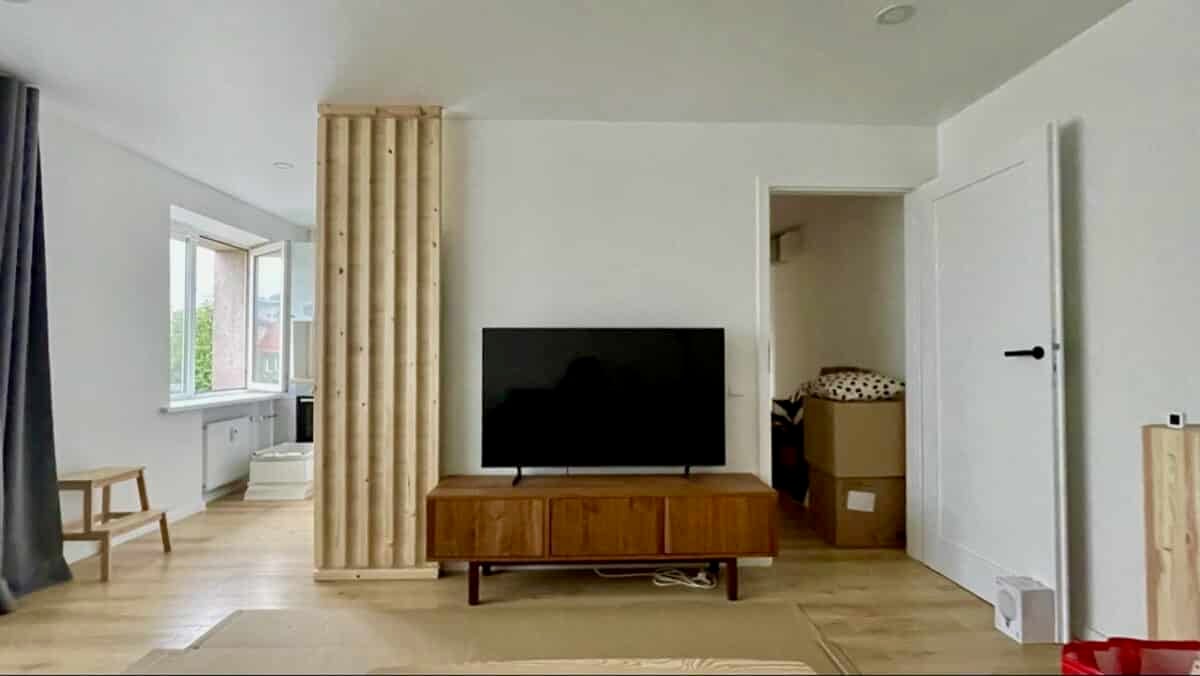 living room with DIY slat wall to hide kitchen fridge
