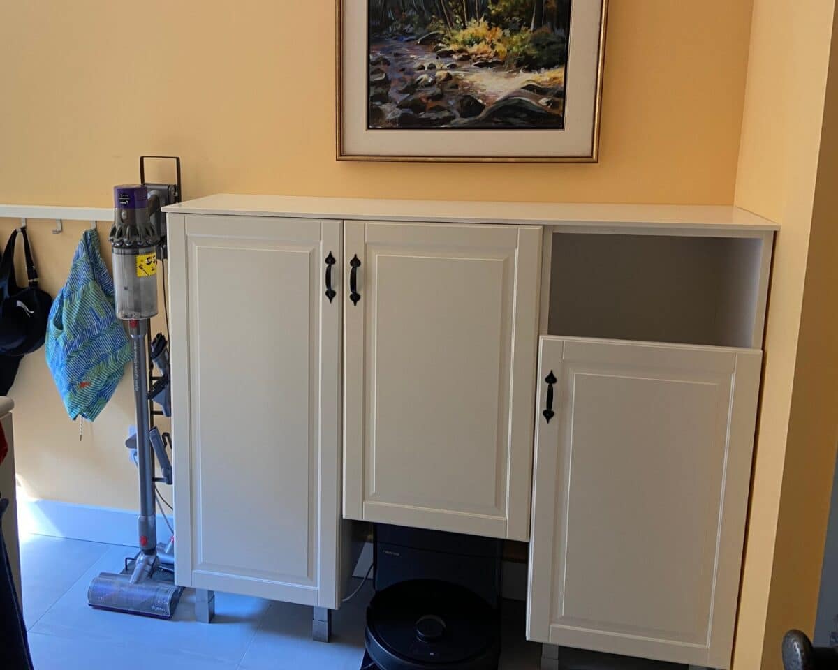 DIY robot vacuum garage and laundry station using IKEA cabinets. Shorter door for easy laundry tossing