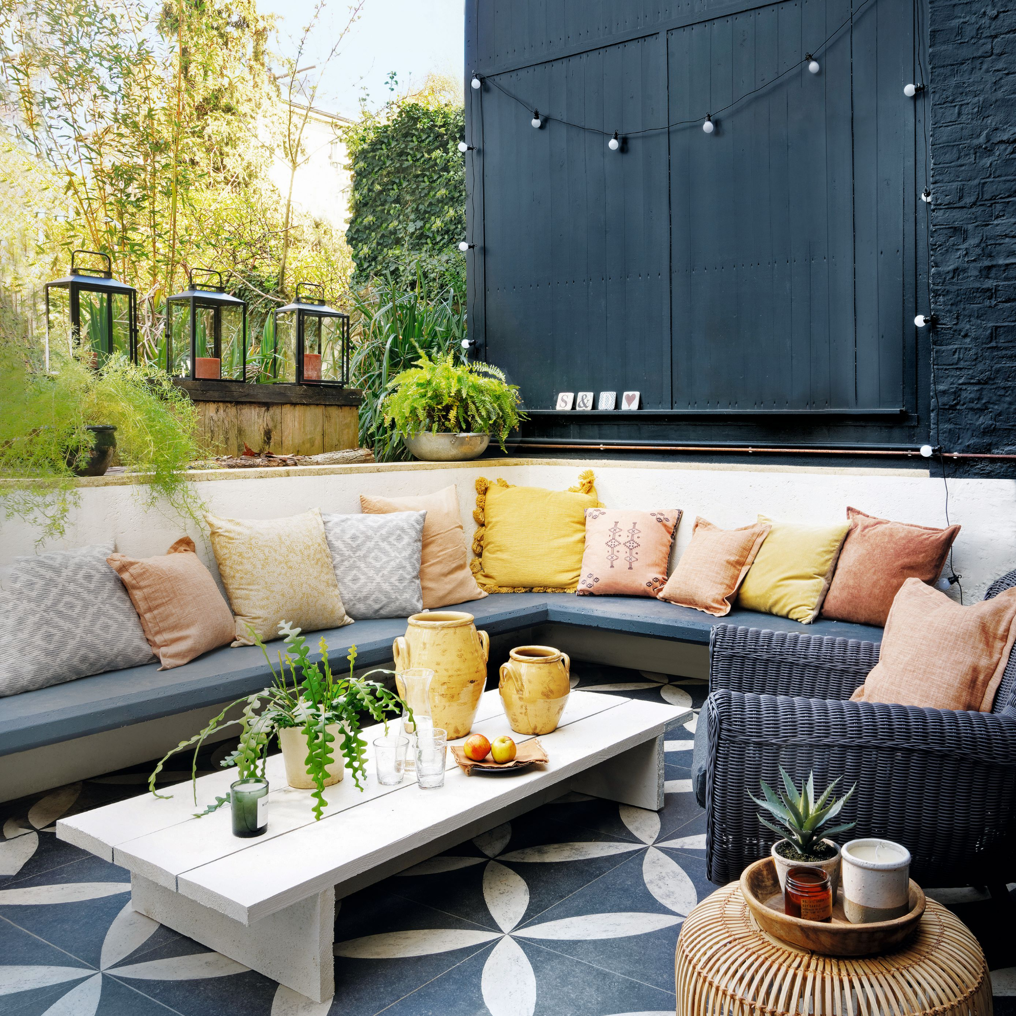A living wall, framework with plants, vertical planting, above a sunken seating area in an urban garden